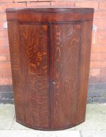 Oak and mahogany bow fronted corner cupboard